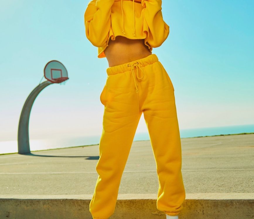 woman in yellow tracksuit standing on basketball court side